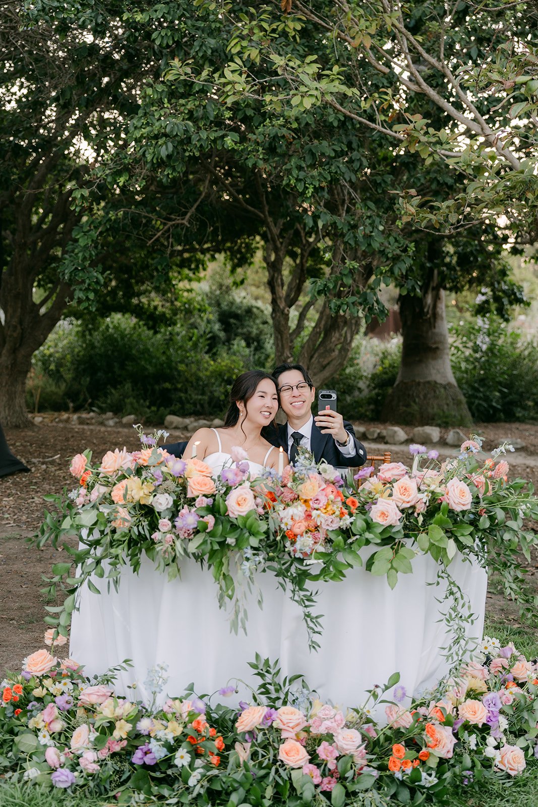 The sweetheart table overflowing with pastel garden flowers