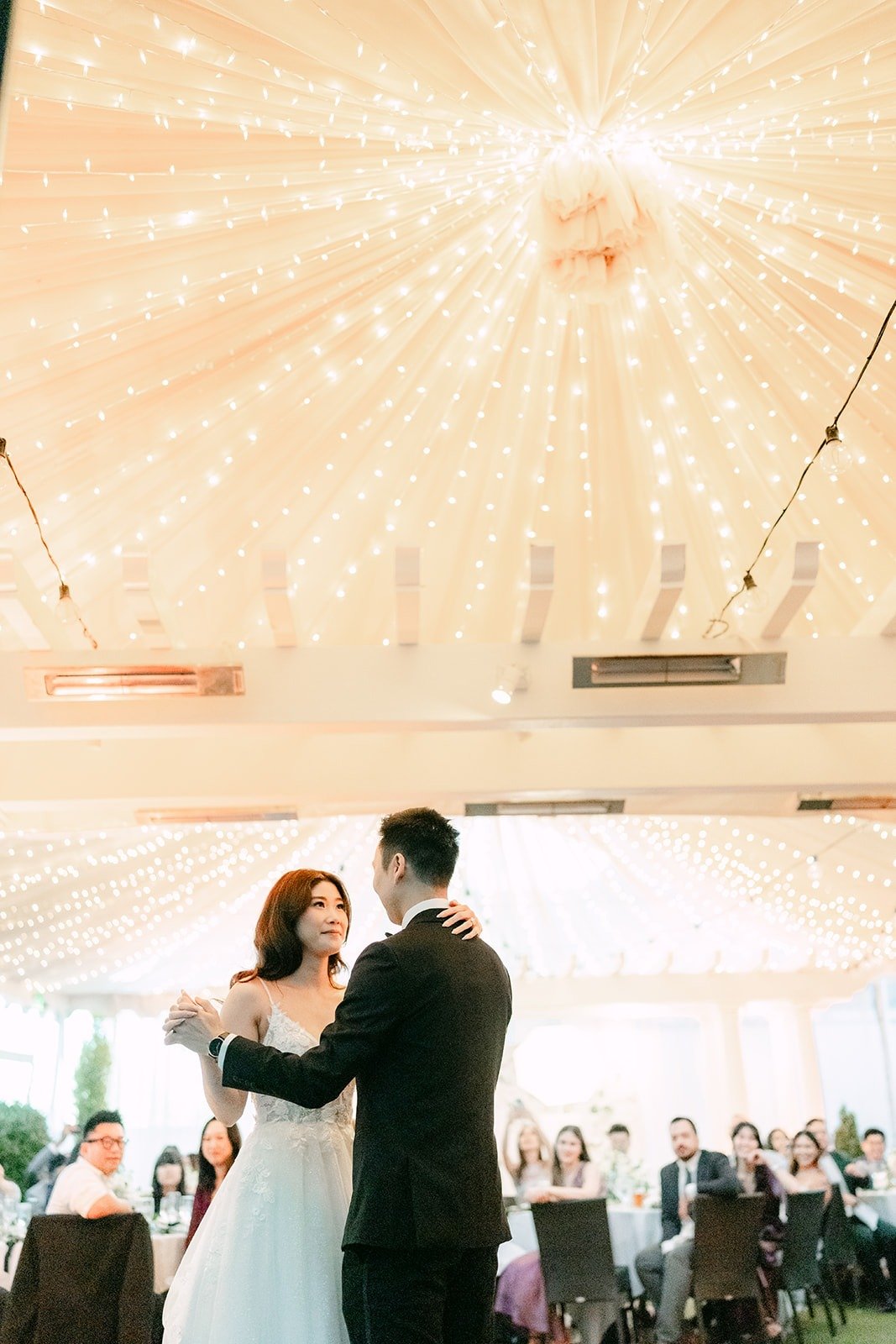 Wide view of the first dance beneath the glowing canopy