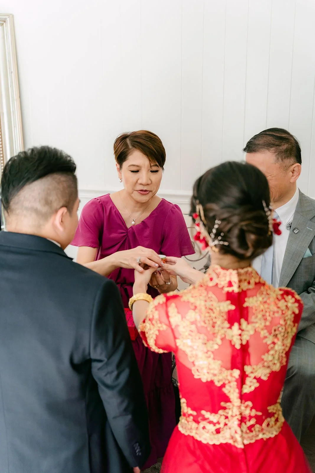 The bride and groom offering tea to a relative during the tea ceremony.