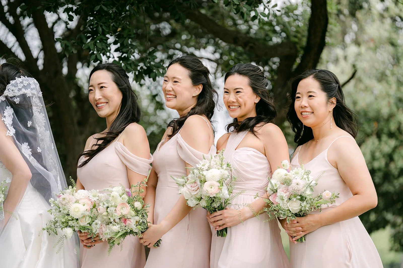 Kristine's bridesmaids holding their bouquets in a row