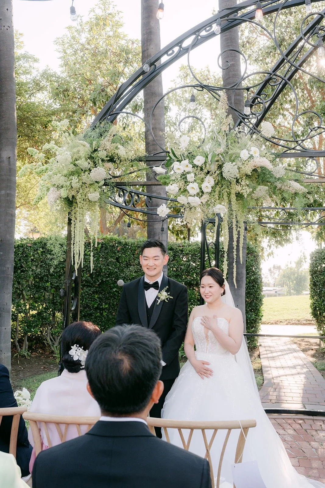 Amy and Sam at the floral arbor during the ceremony