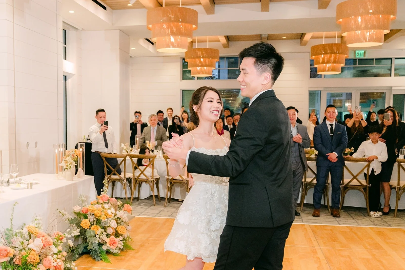 Angela and Eli dancing as guests watch from their tables