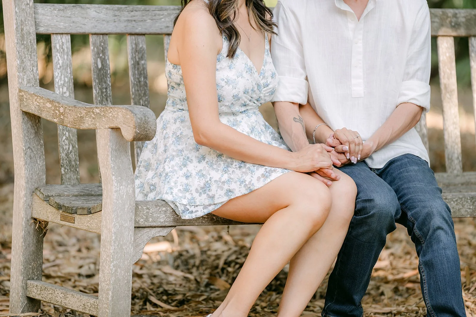 Francesca and Daniel sit side by side on a wooden garden bench.