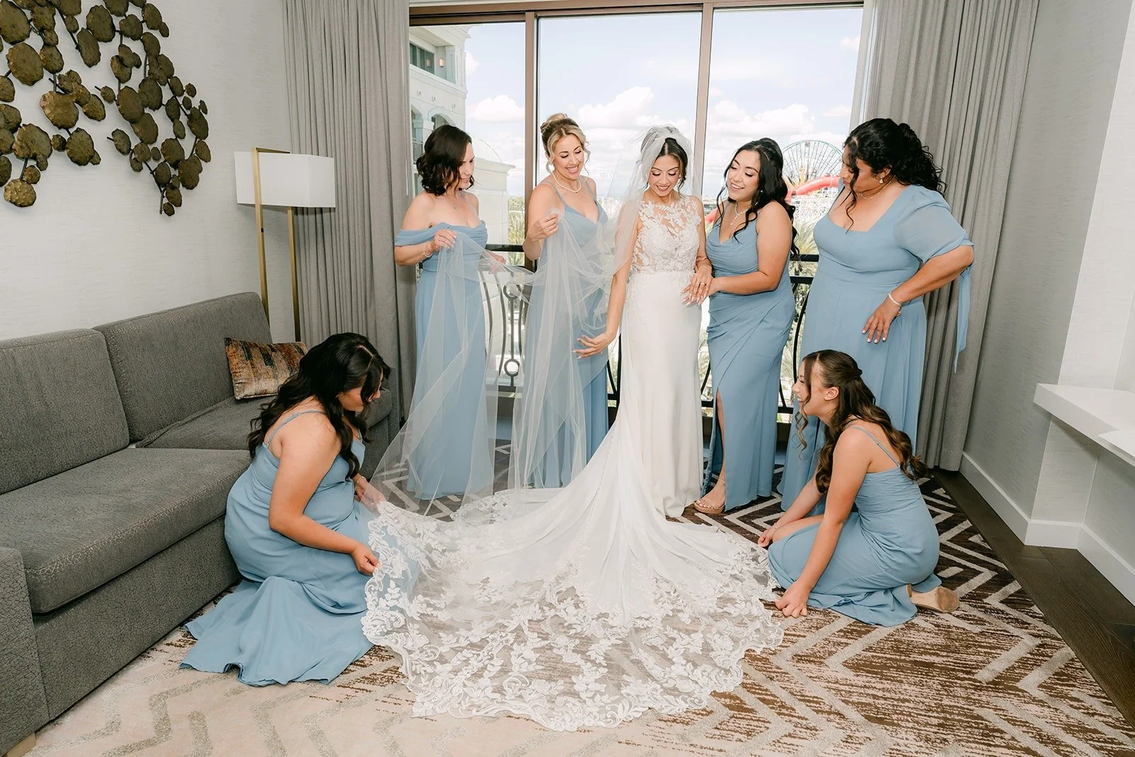 Bridesmaids in light blue fluff Francesca's train in the Bride Suite
