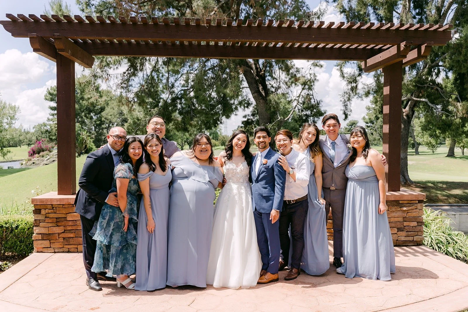 Natalie and Mark with friends under the wooden pergola outside