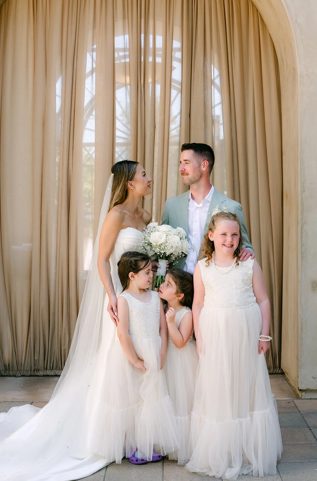 Bride and groom with two flower girls in white tulle dresses