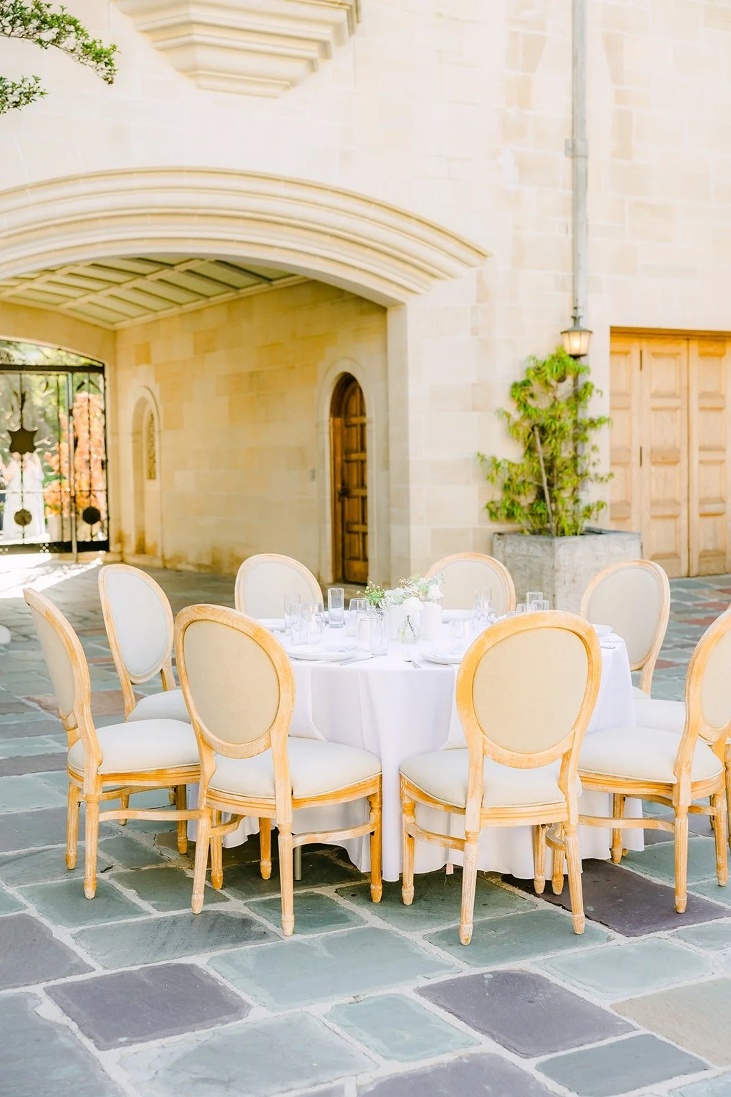 Reception tables with cream chairs in the Greystone Mansion courtyard
