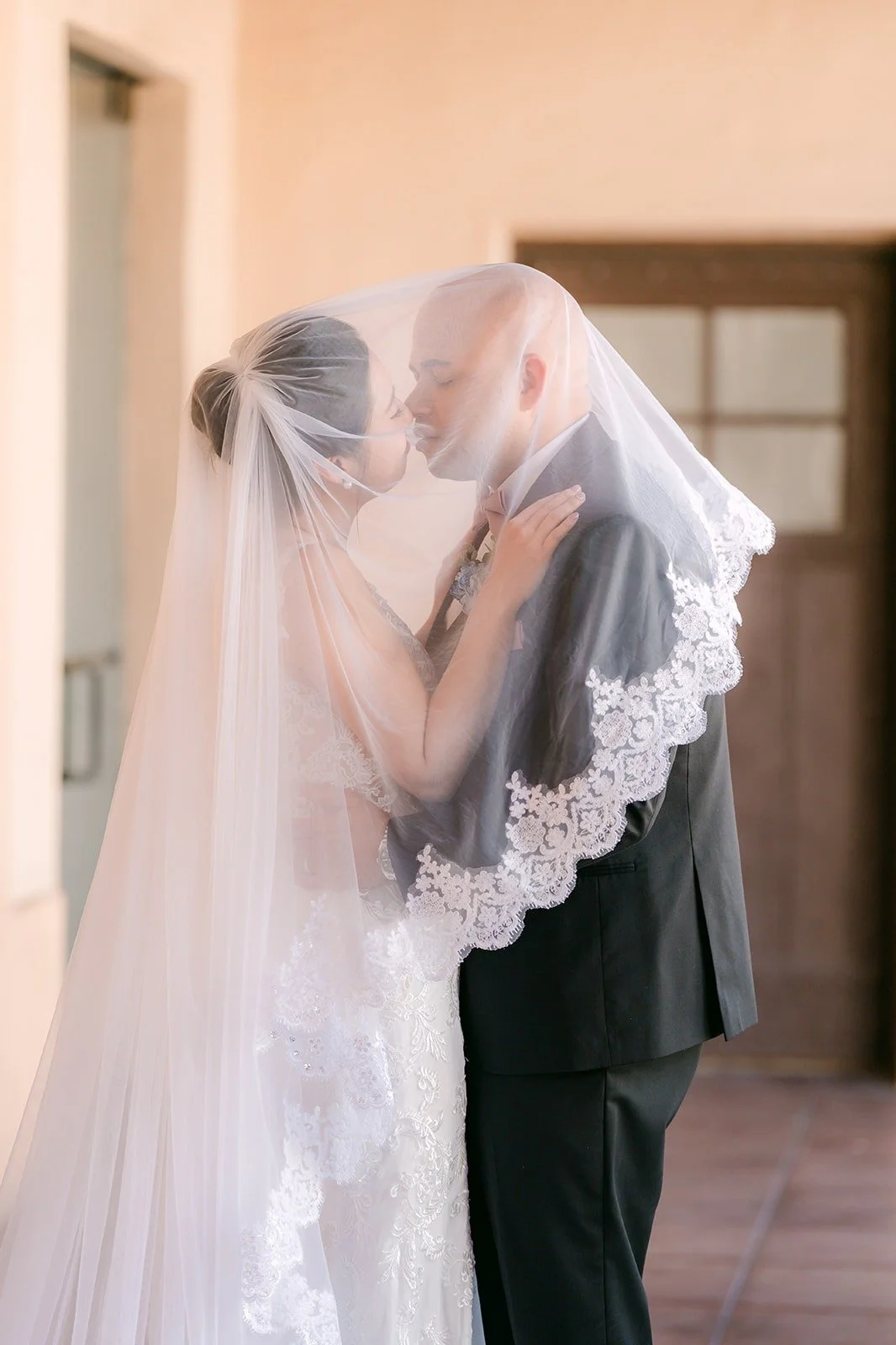 Elisa and Brandon kiss under her lace veil