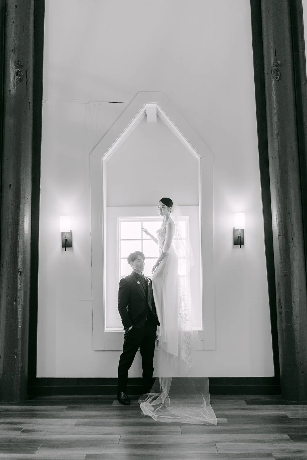 Tin and Fong framed by the dark beams and arched window