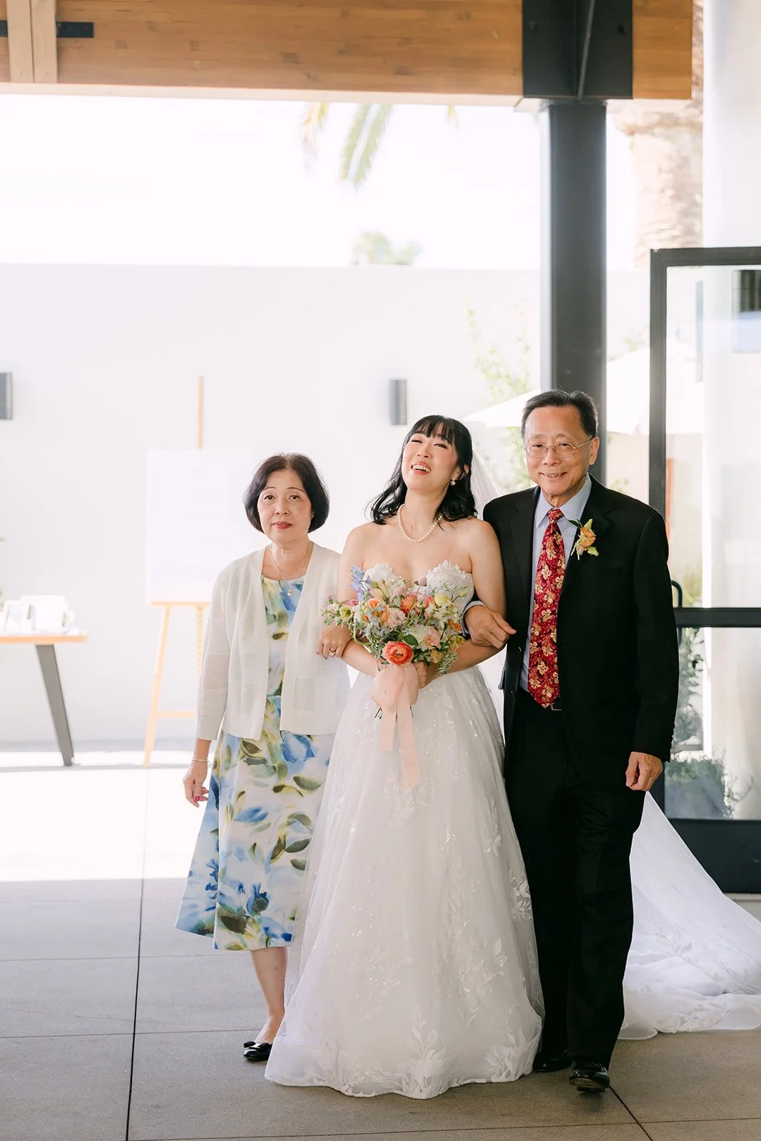 Vivian walking down the aisle with both of her parents at The Colony House