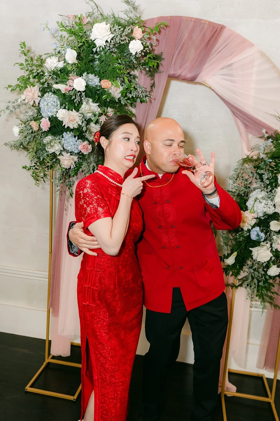 Elisa and Brandon in red at the floral arch