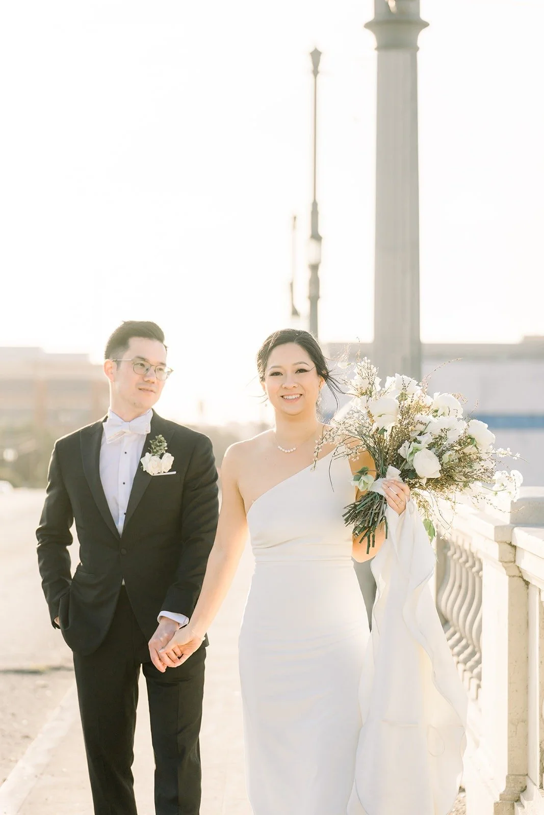 Cindy and Alex walk hand in hand across the rooftop, photographed by One and Only Production