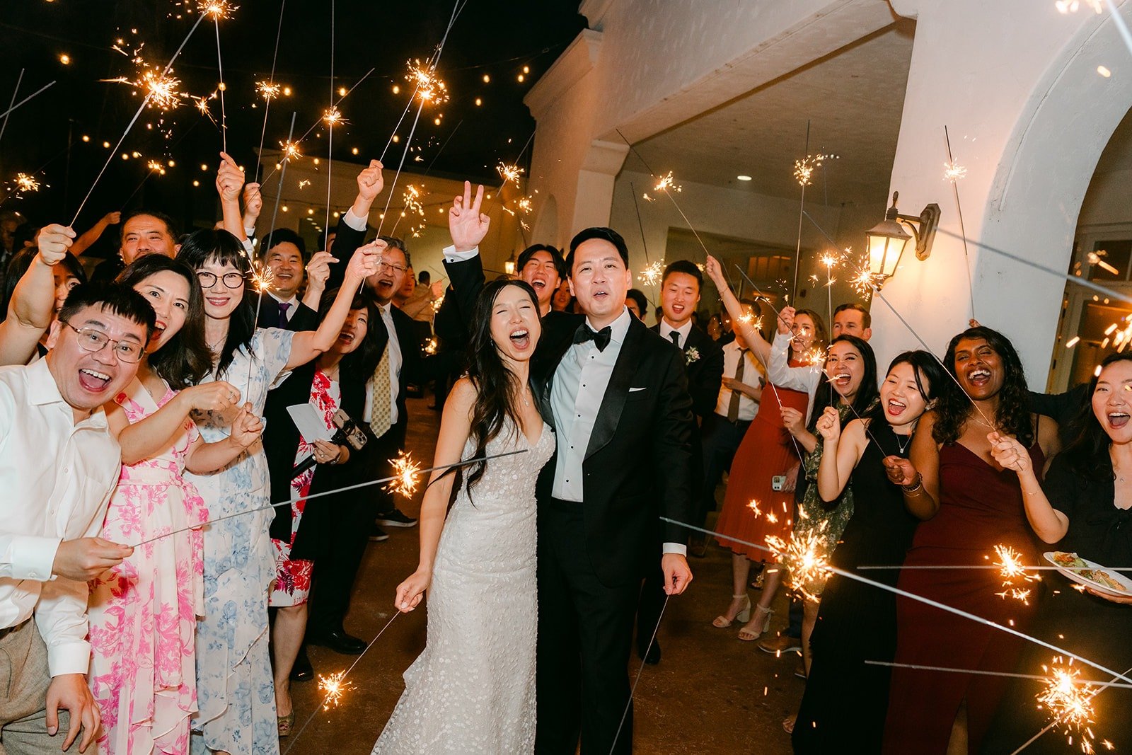 Guests waving sparklers as Kristine and William pass