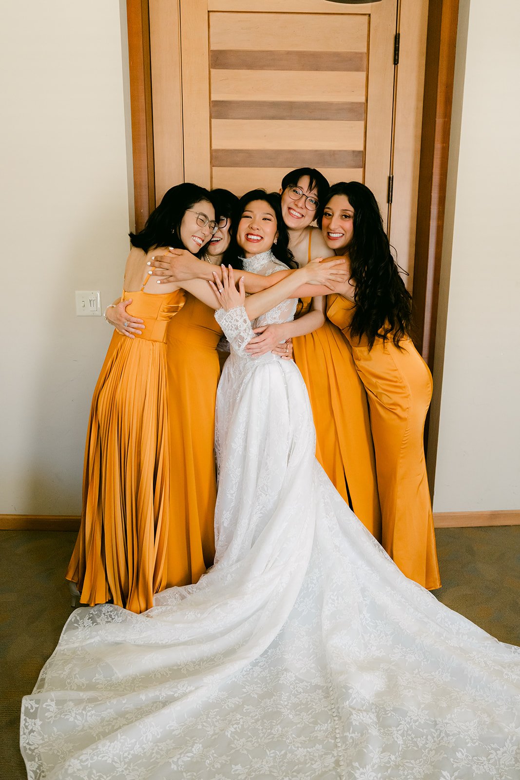 Bridesmaids hugging Kim in the bridal suite