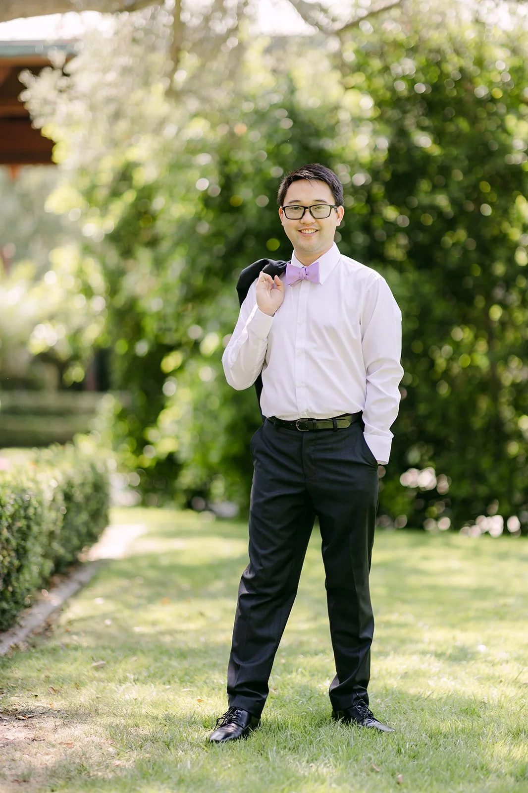 Patrick in the garden with his jacket over his shoulder