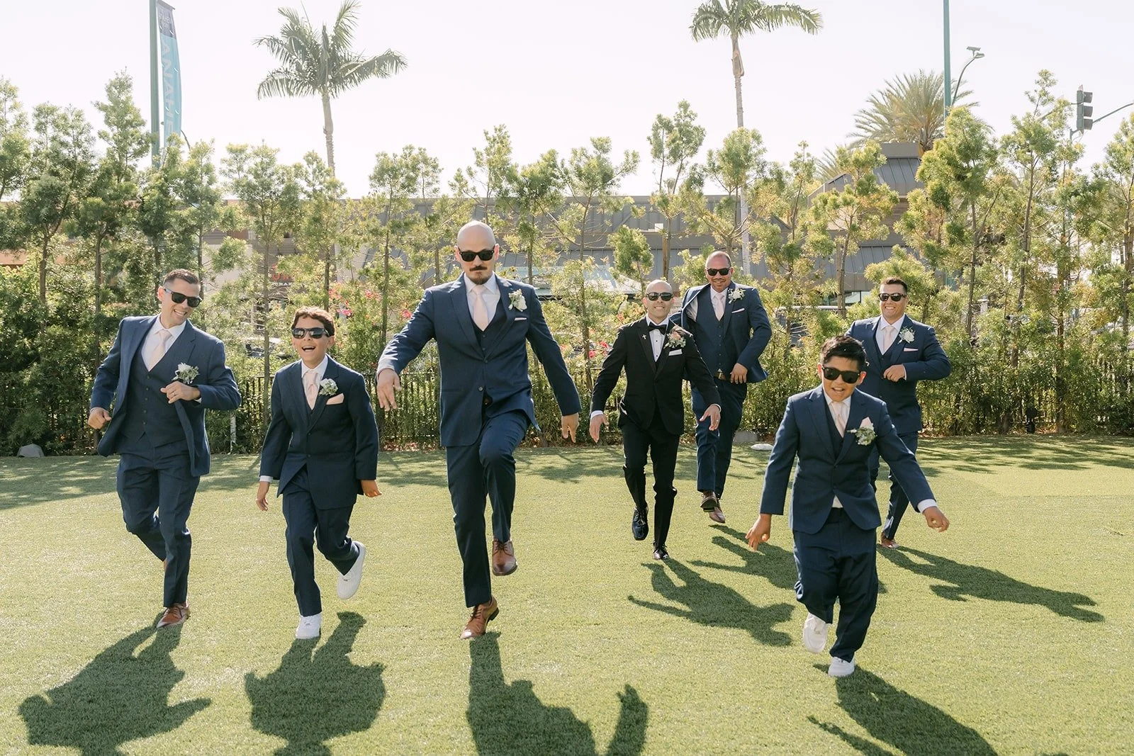 Daniel and the groomsmen walk across the lawn at The Westin Anaheim Resort, photographed by One and Only Production