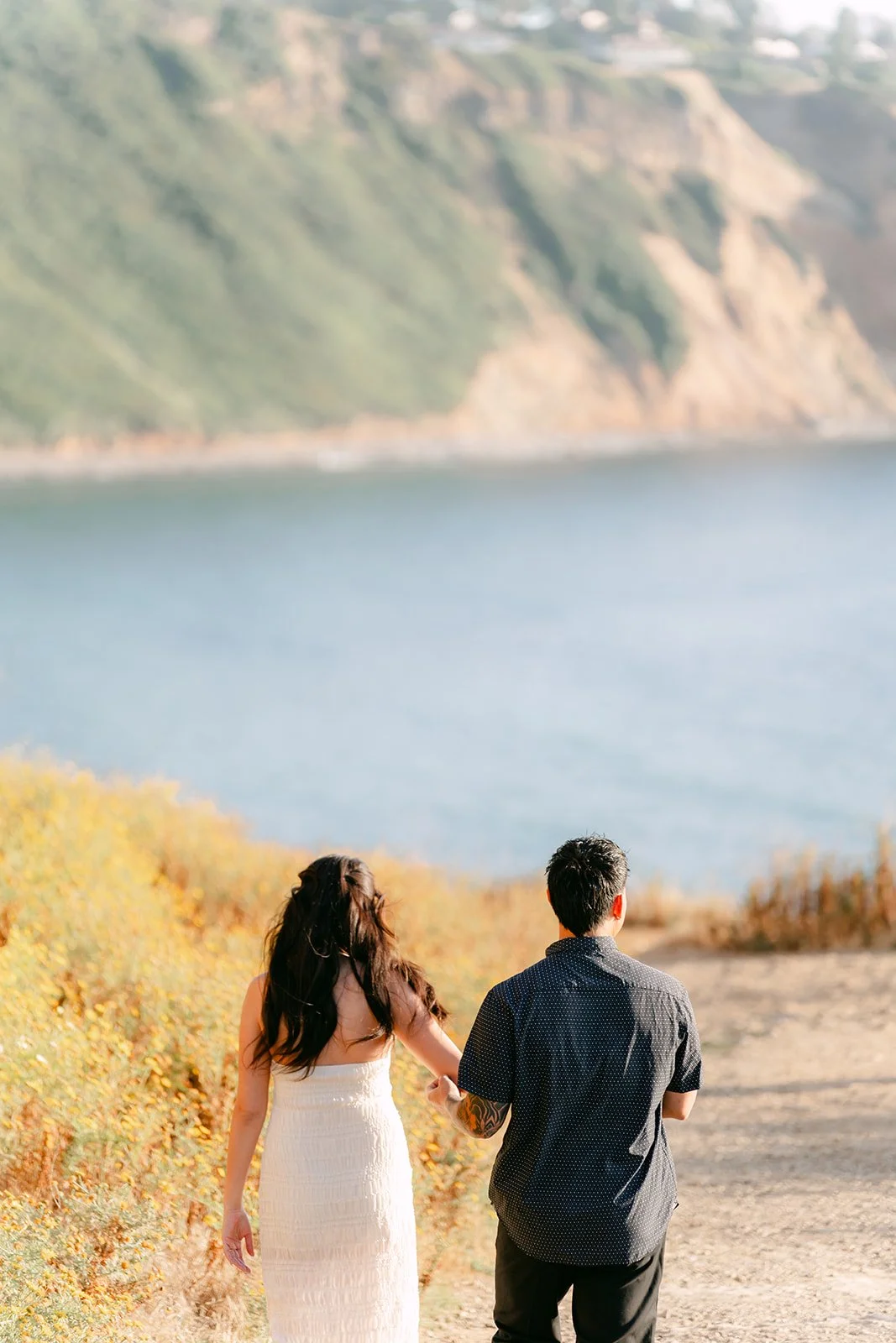 Victoria and Andrew stand on the trail overlooking the cove and cliffs.