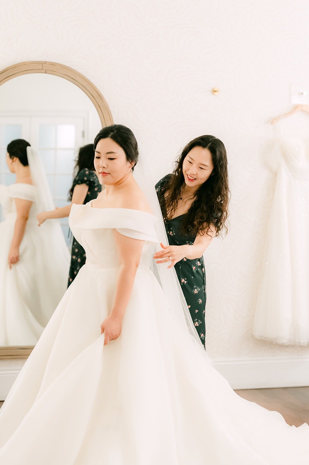 A woman helping Chorok with the back of her off the shoulder gown
