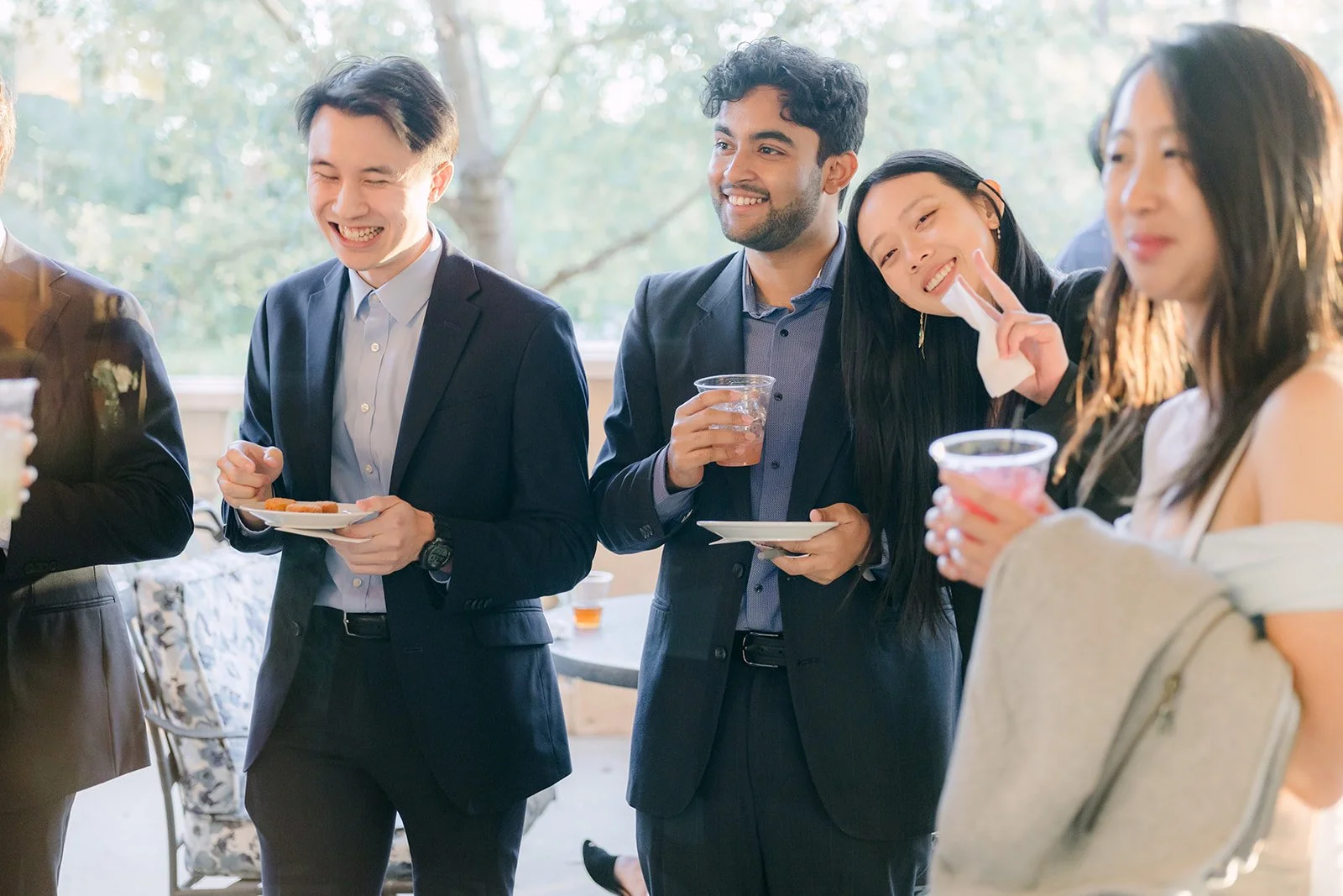 Friends laughing together with drinks at cocktail hour