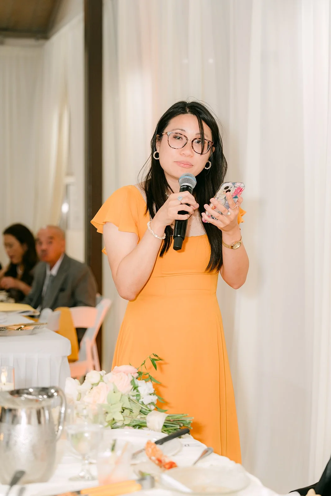 A bridesmaid in marigold giving her toast