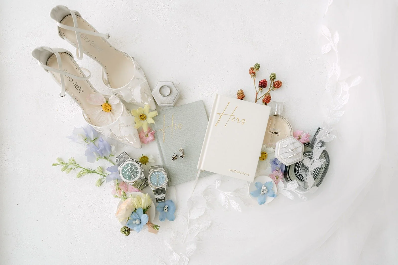 Kylie and Mario's flat lay of heels, rings, watches and pastel blooms for their Surf & Sand Resort wedding
