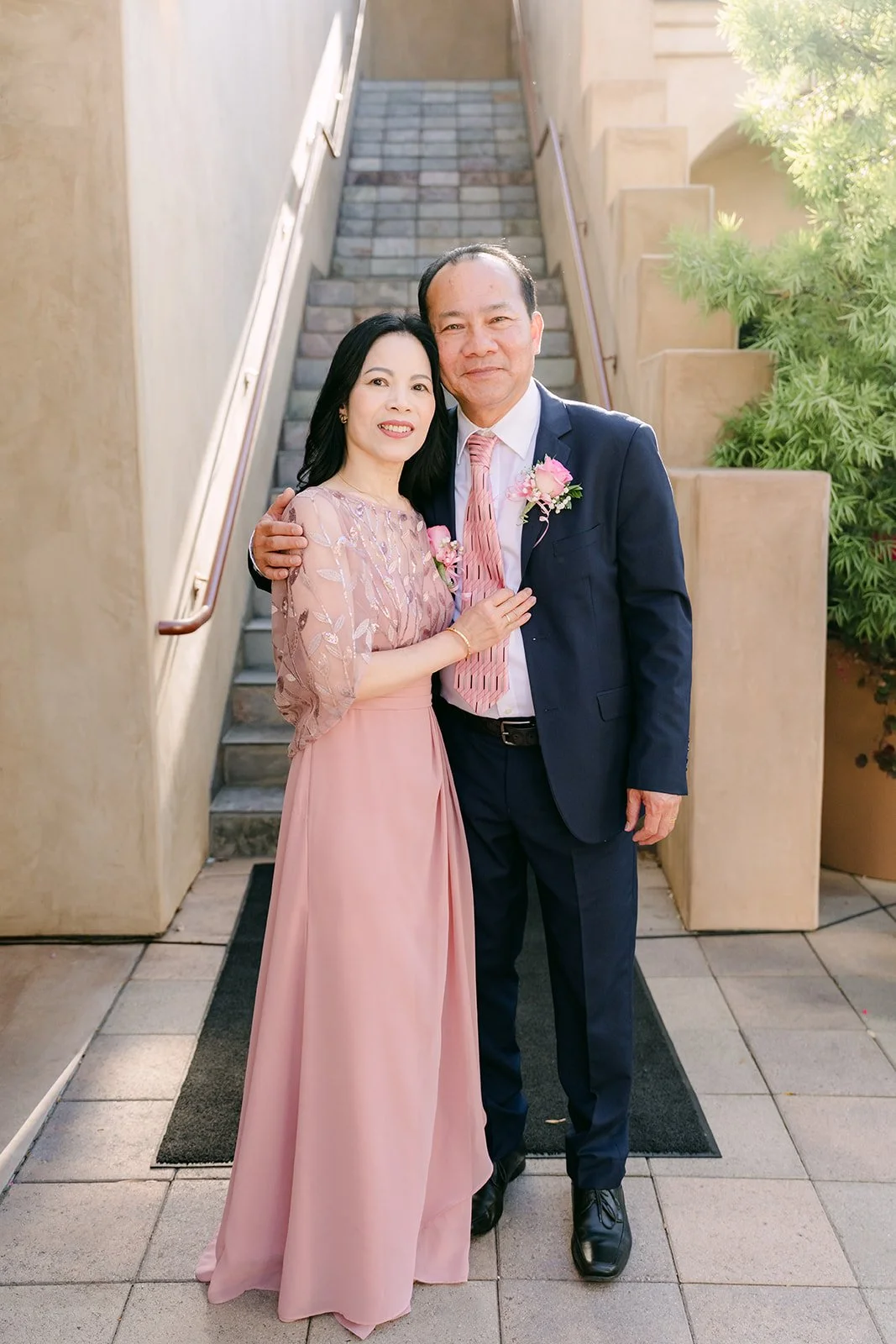 Bride's parents smiling together on the courtyard stairs