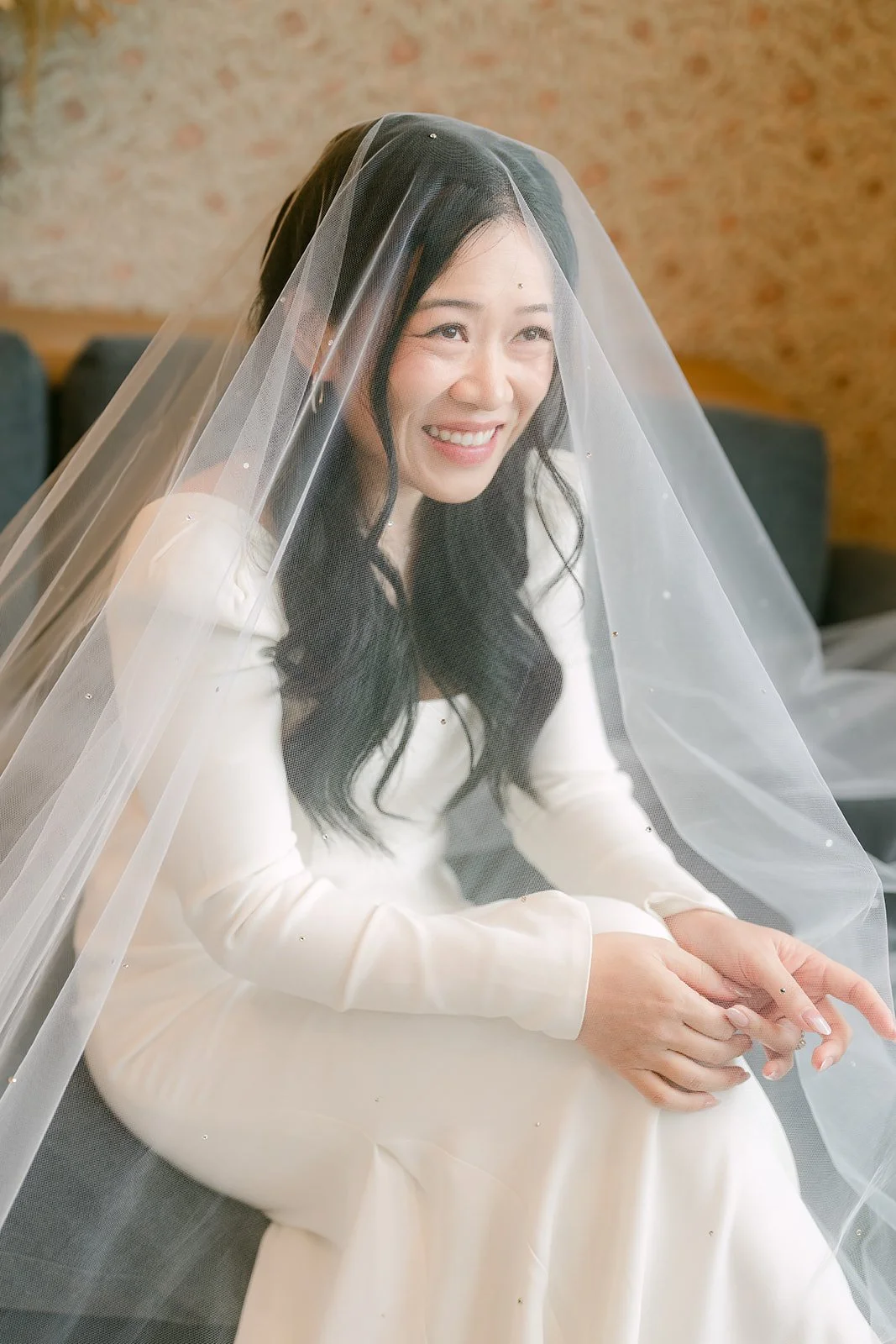Denise laughing under her veil in the bridal suite.