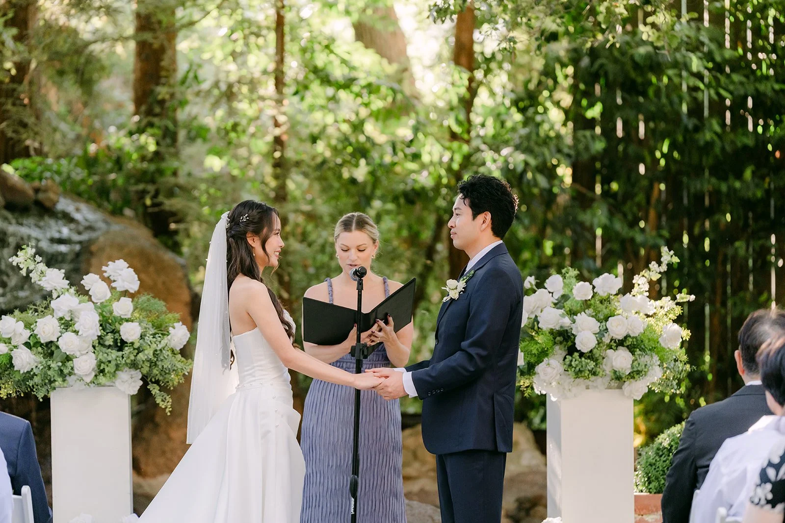 Nhi and Shogo holding hands as officiant Emily begins the ceremony