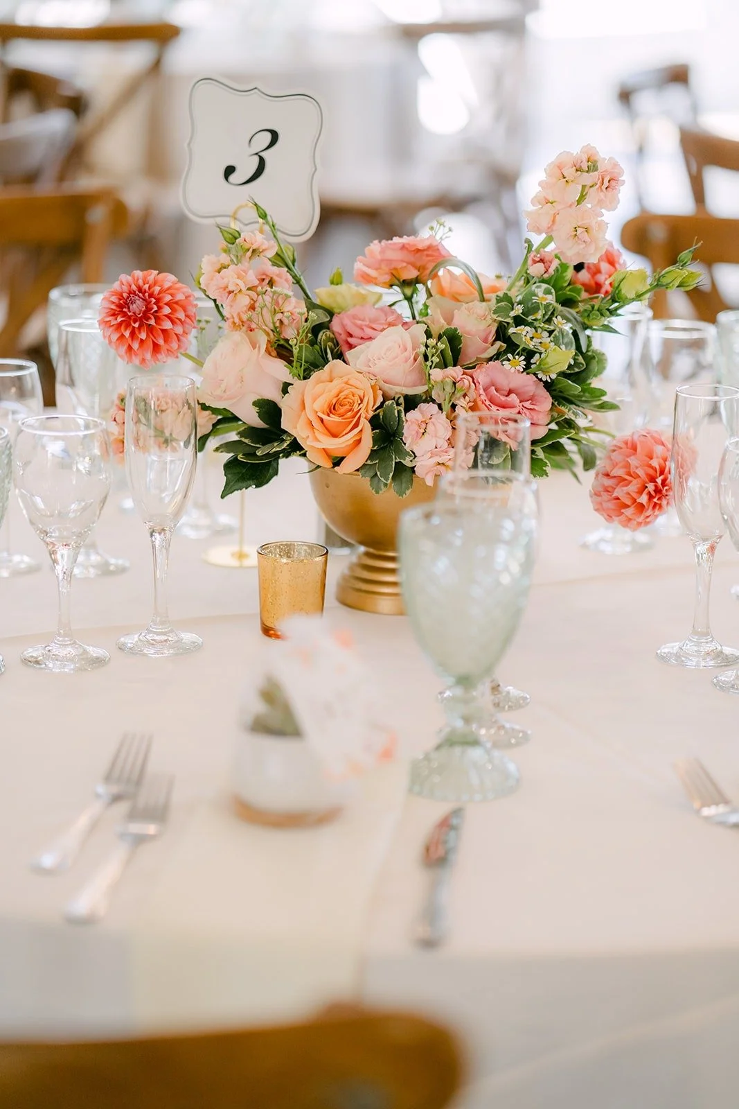 Table florals in pink and peach beside a table number