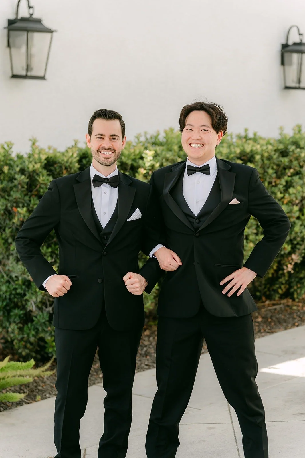 Kevin and a groomsman flexing for the camera outside the venue, photographed by One and Only Production