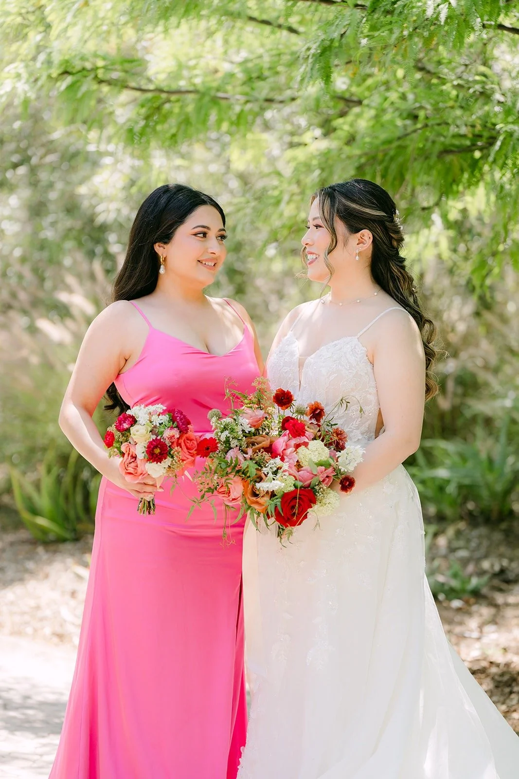 Joanne and a bridesmaid in pink smiling together with their bouquets