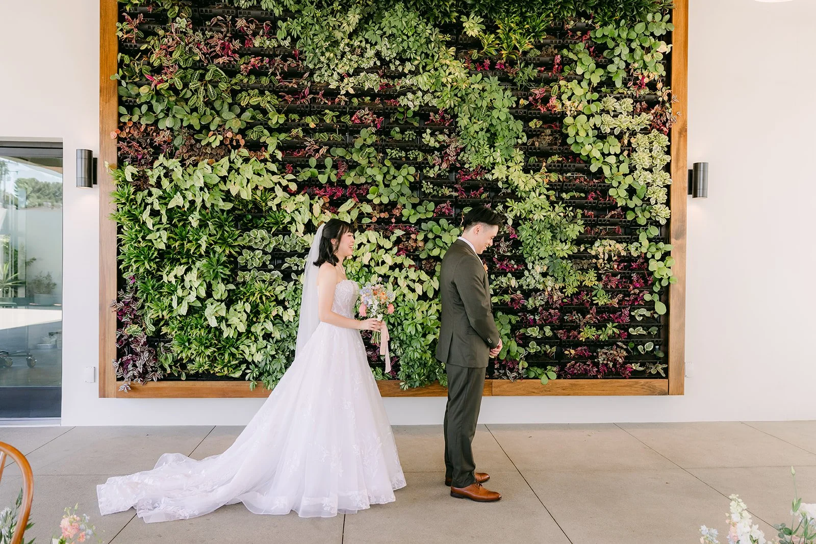 Vivian walking toward Alex at the living wall