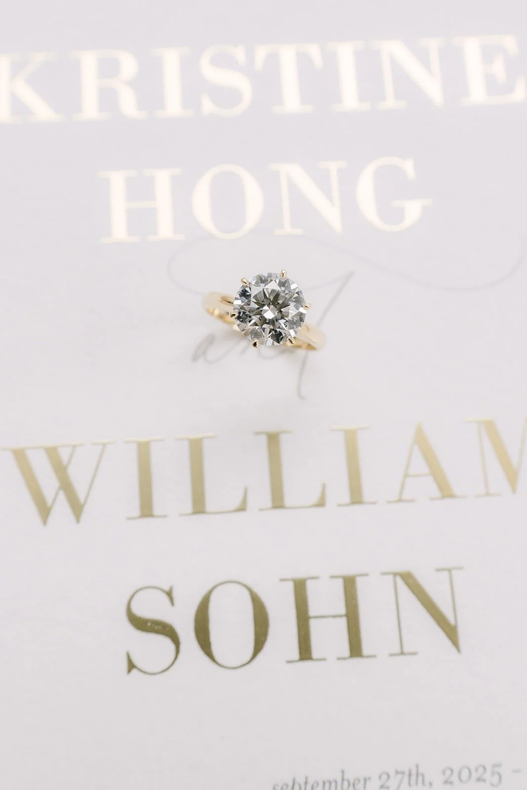 Engagement ring resting on the wedding invitation
