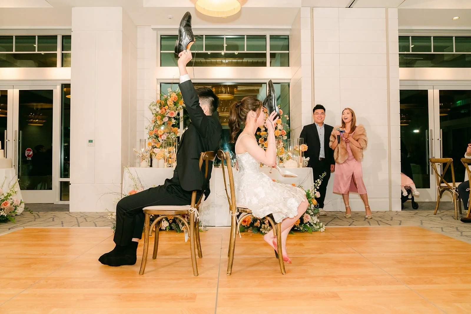 Angela and Eli seated in the middle of the floor for a reception game