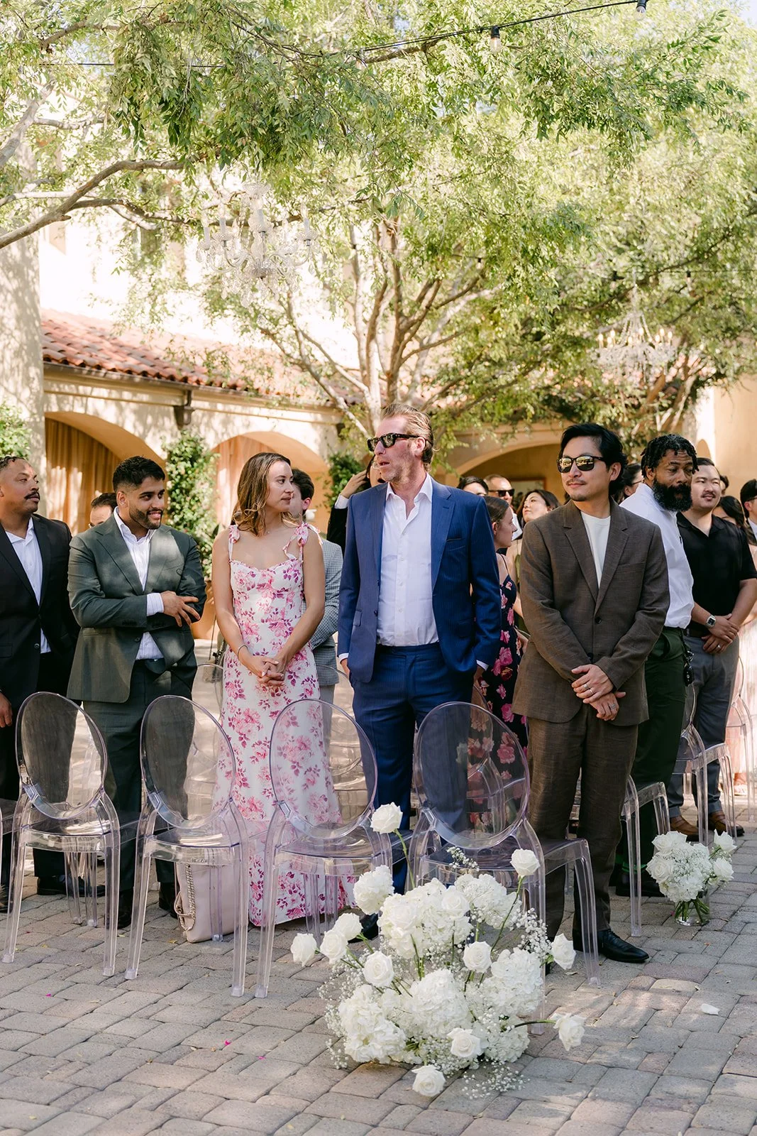 Guests standing and cheering as the couple exits, photographed by One and Only Production