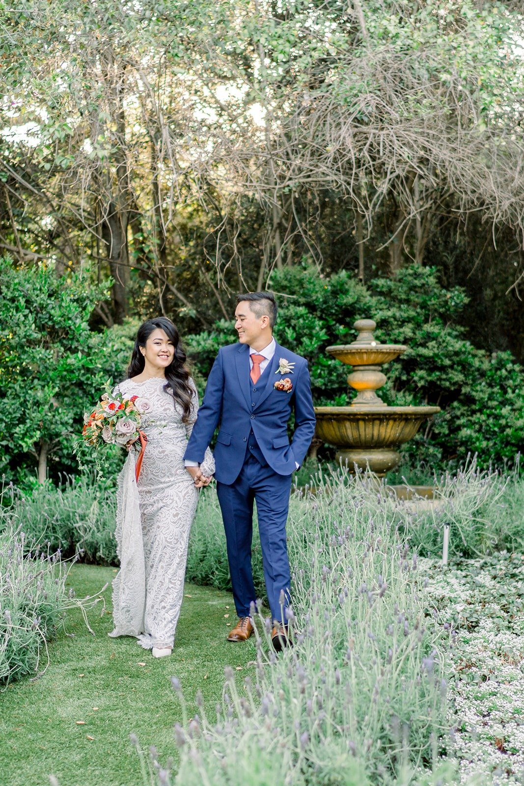 Hannah and Vincent walking hand in hand along the garden path