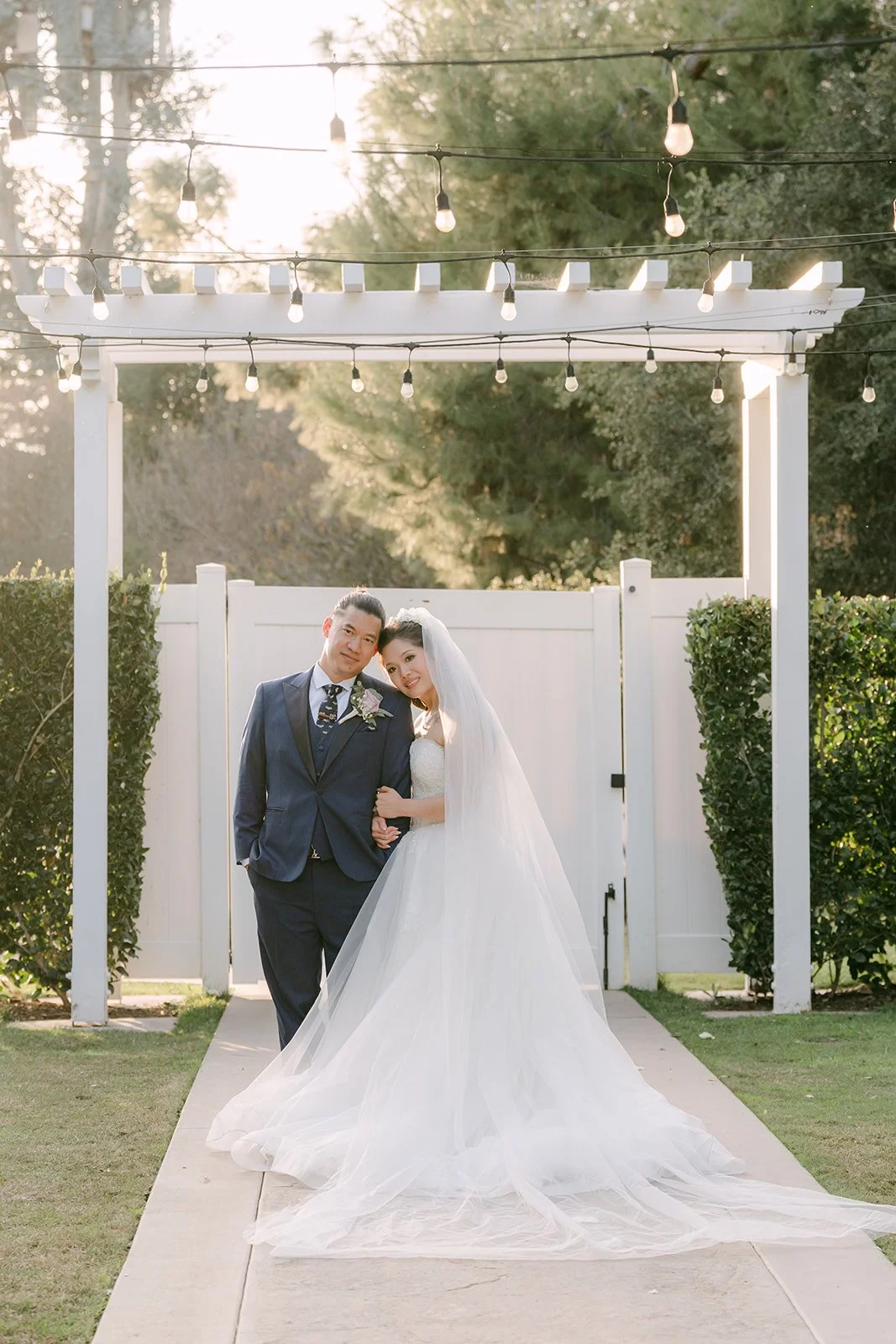 Kate and Michael under the white pergola at Sierra La Verne.