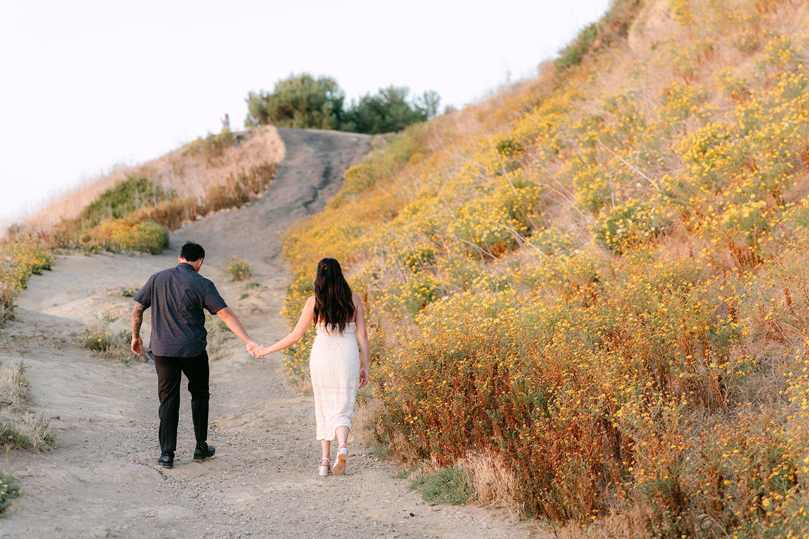 Victoria and Andrew walk down the dirt trail toward the cliffs.