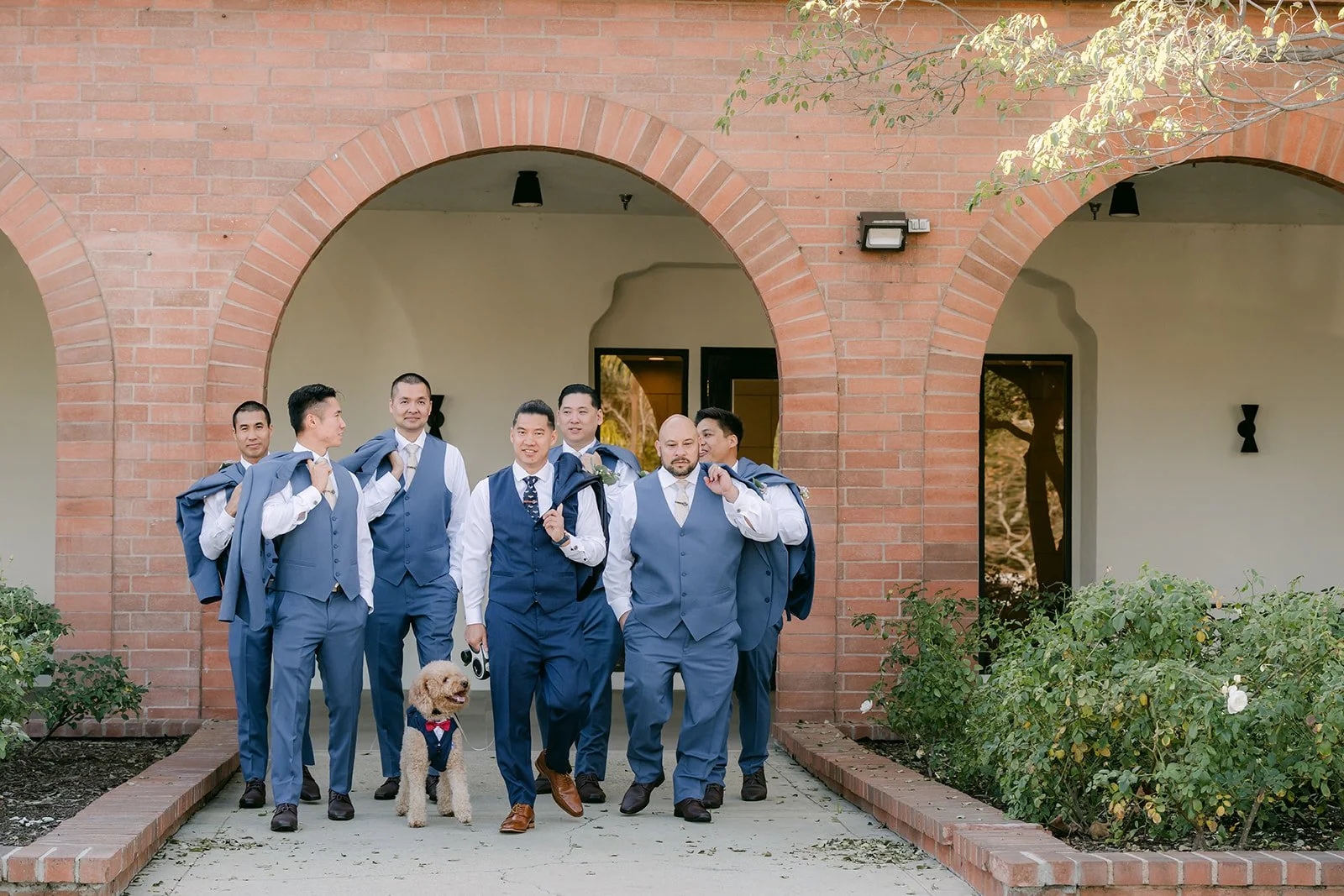 Michael and his groomsmen striking a fun pose in the courtyard.
