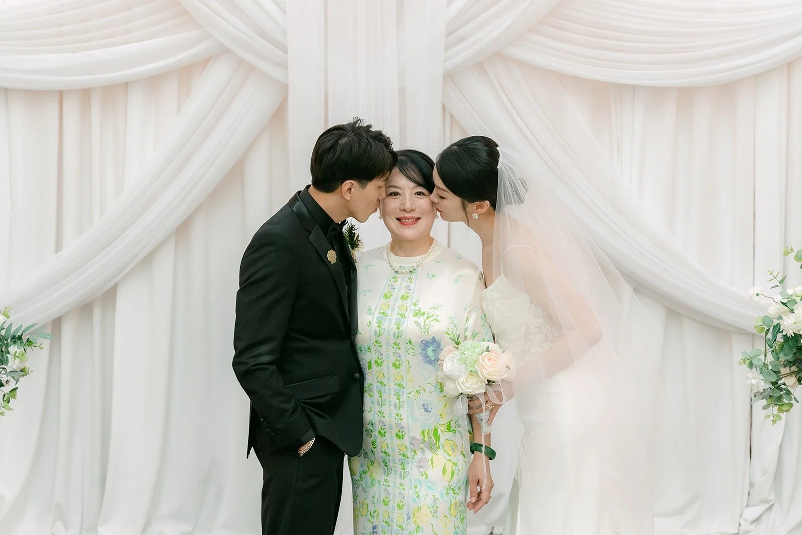 Tin and Fong kissing in front of the white drapes in the chapel