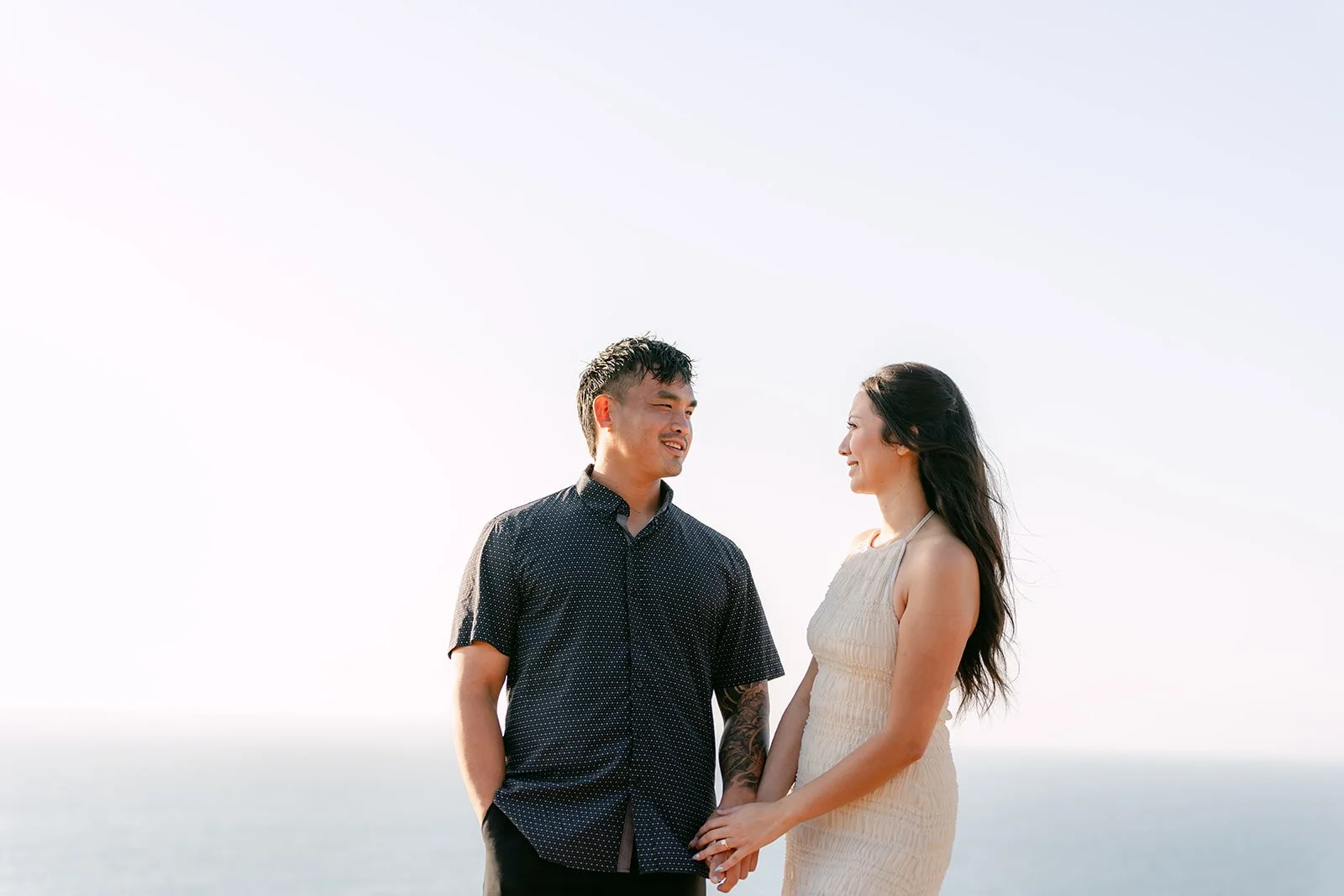 Victoria and Andrew stand together above the ocean on the Palos Verdes coastline.