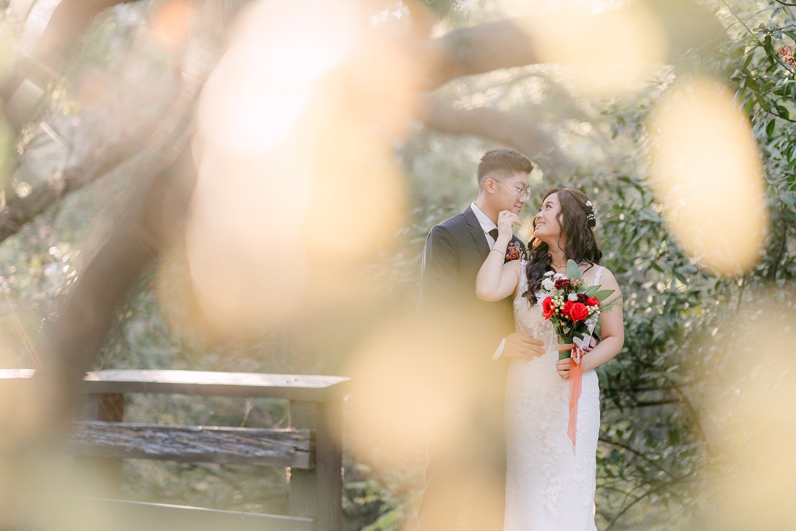 Shayna and Robert framed by soft foreground leaves