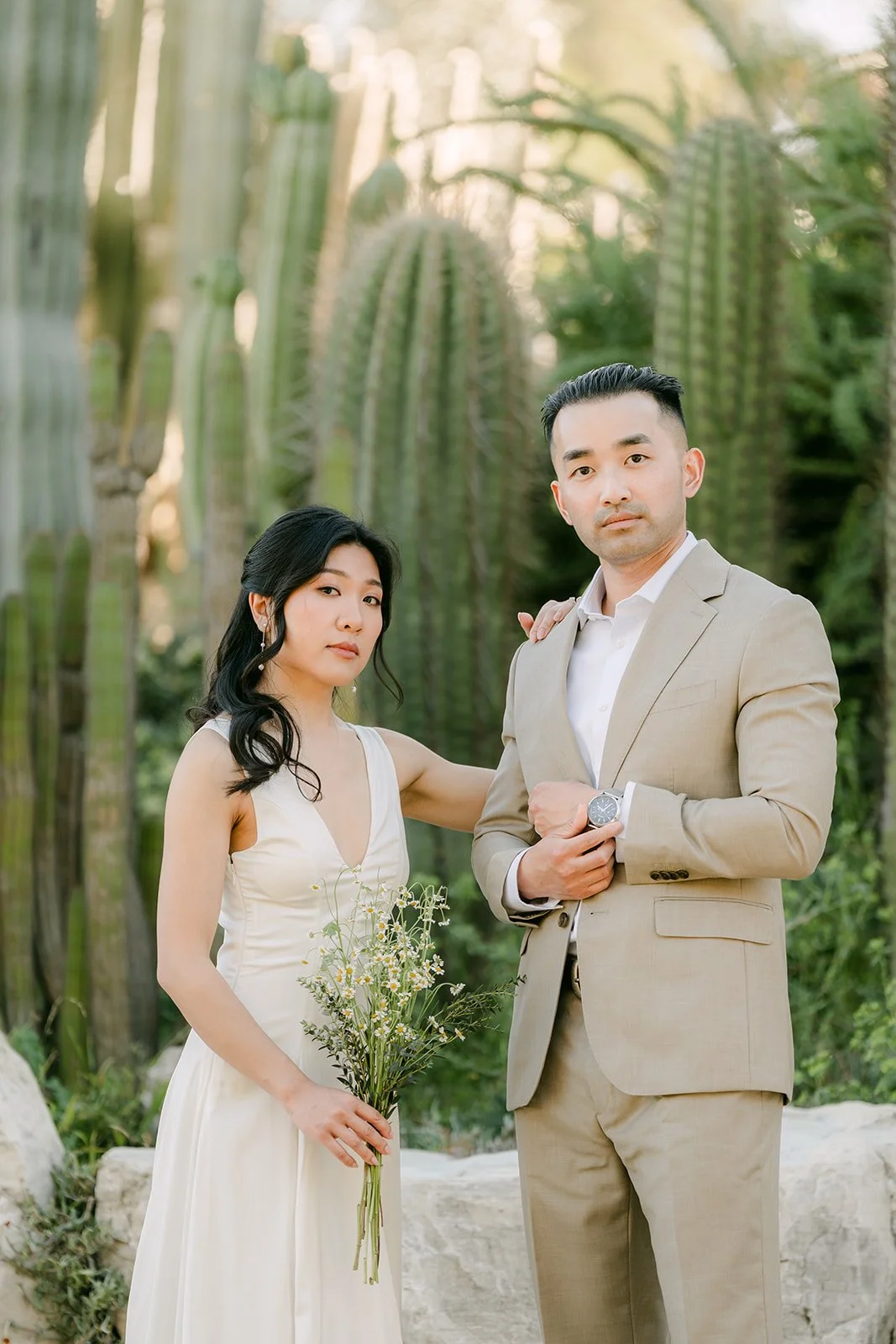 Kim and Vincent smiling arm in arm in the cactus garden.