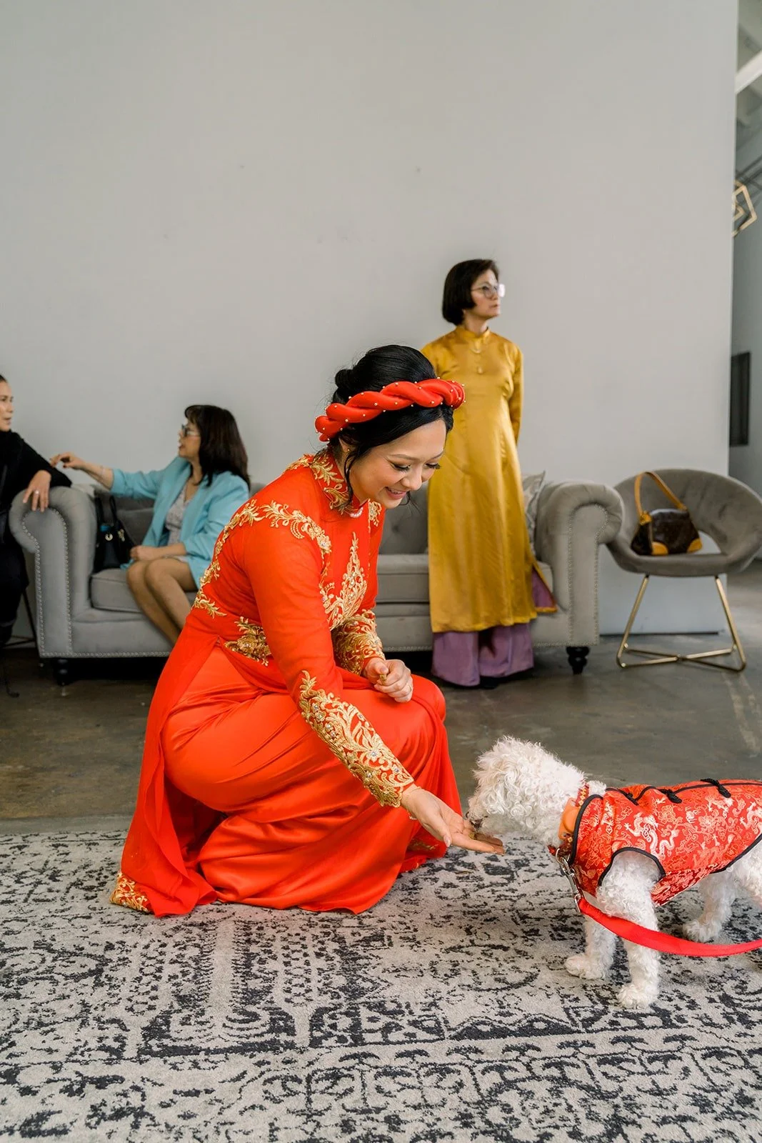 Cindy greets the white dog in its red outfit during the tea ceremony