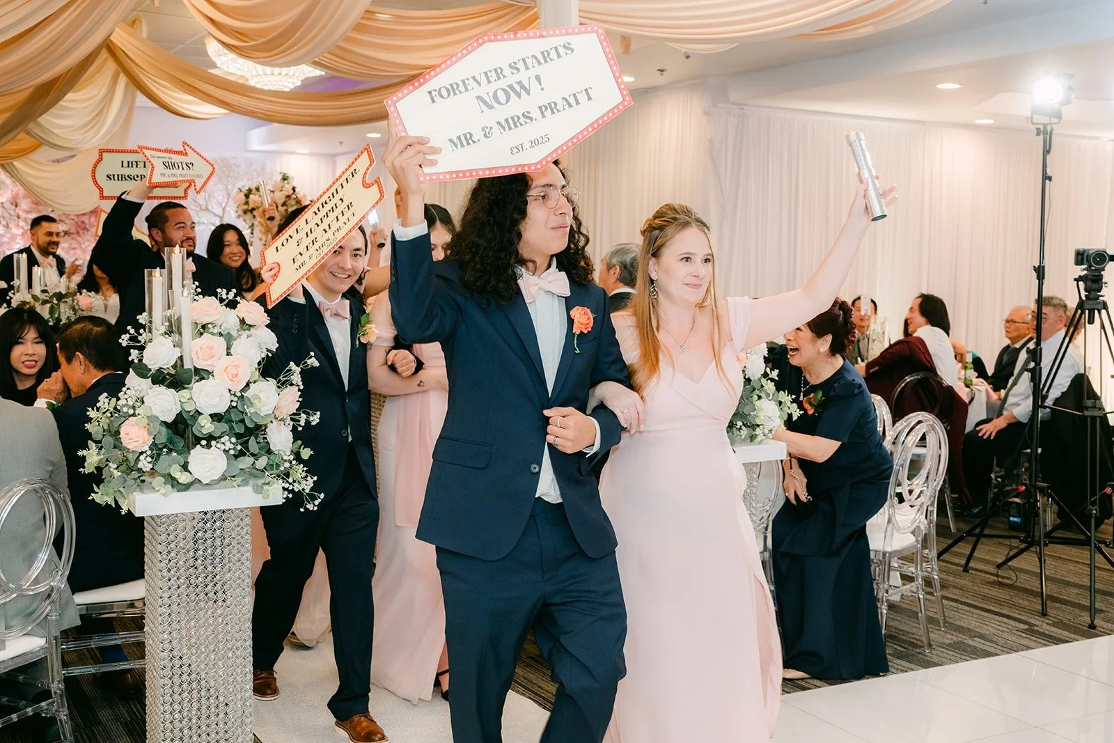 The wedding party making their entrance with props and big smiles