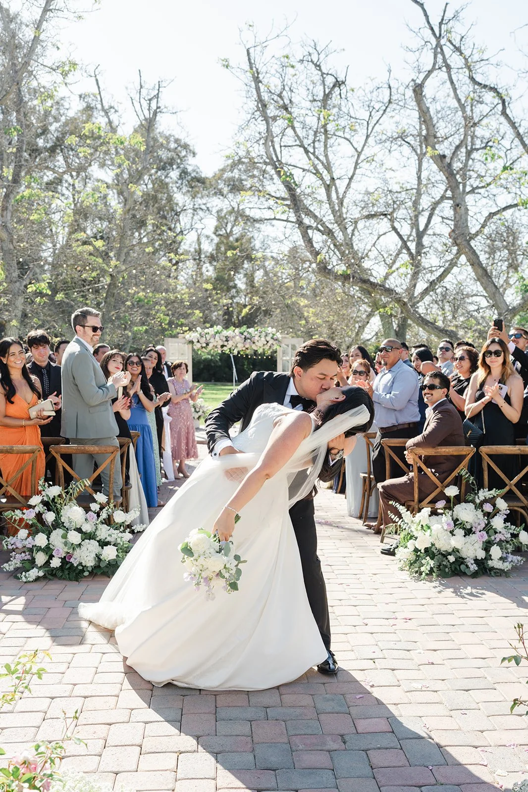 Groom dipping the bride for a kiss in the aisle