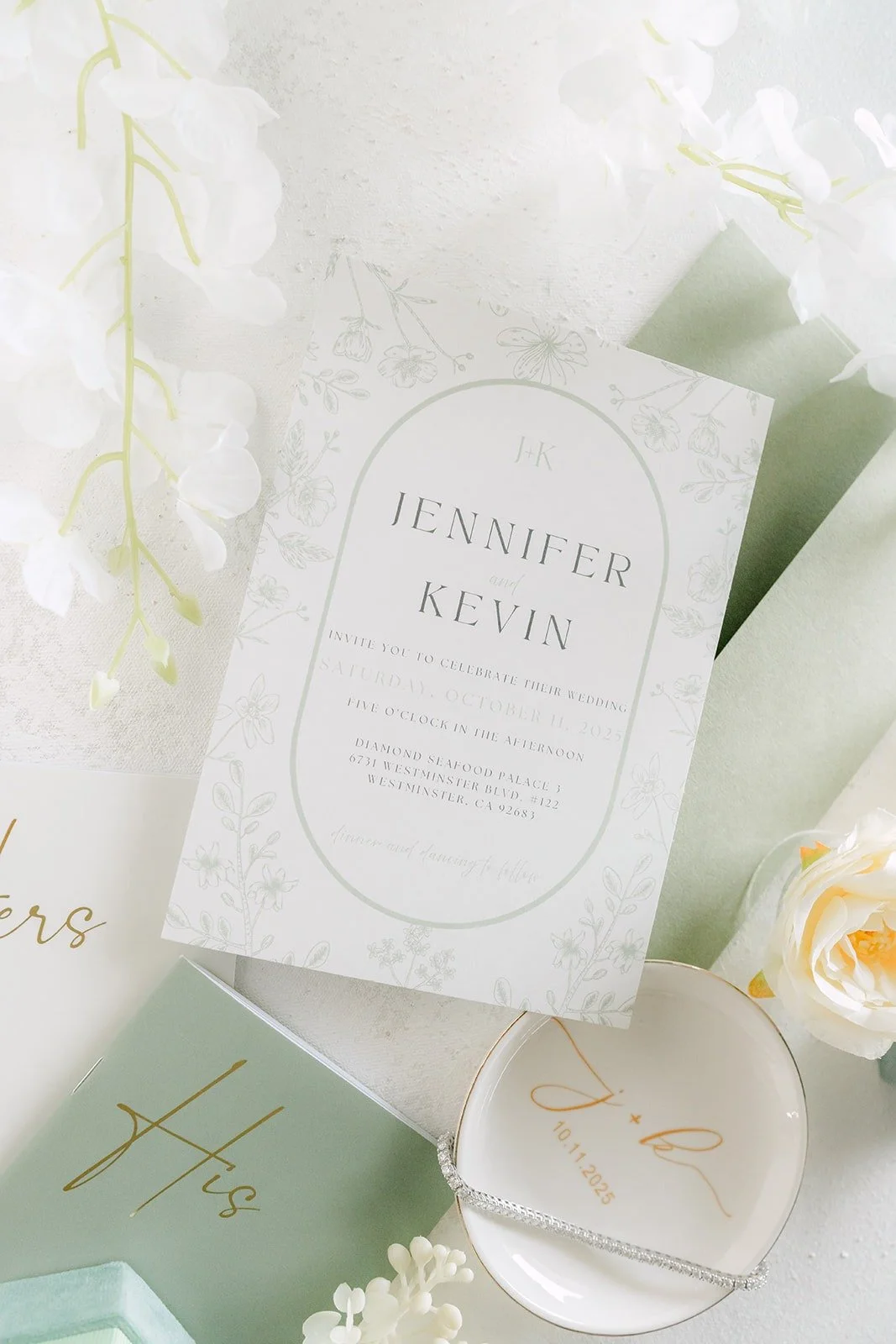 The sage and white invitation suite styled with white roses
