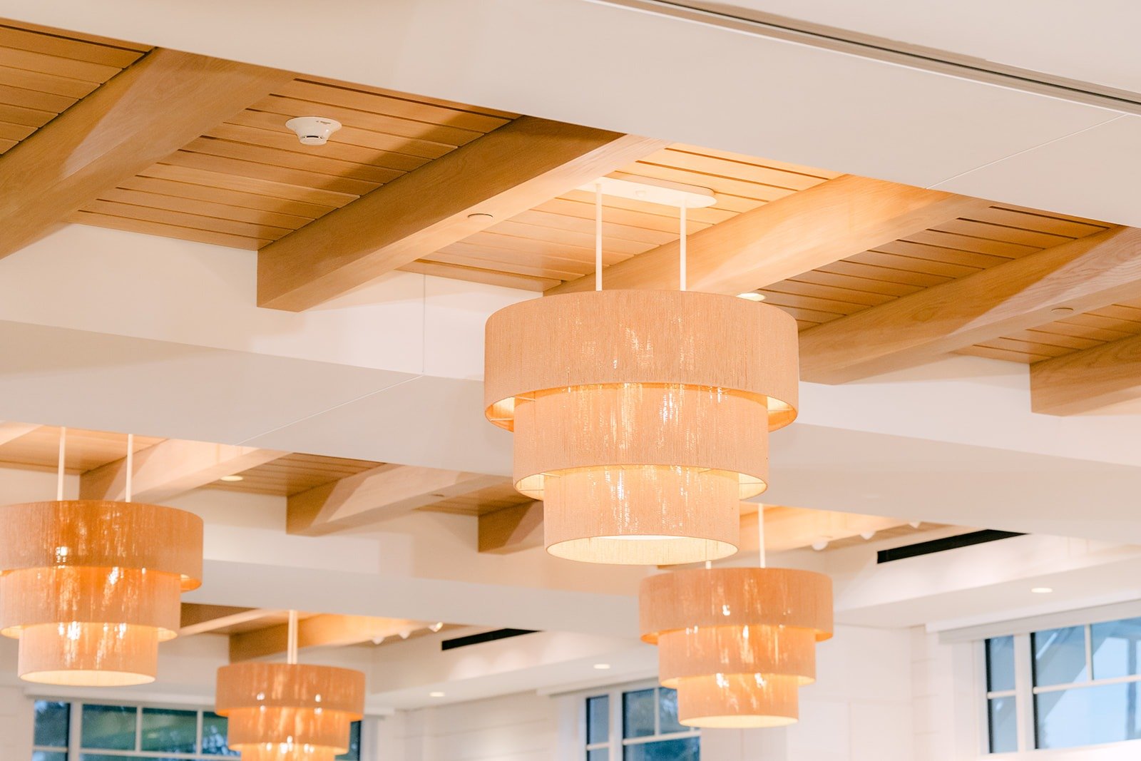 Rattan pendant chandeliers hanging from the wood beam ceiling of the ballroom