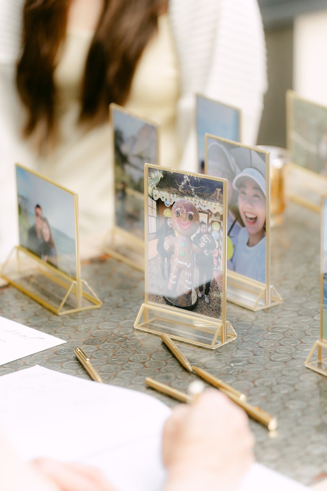 Framed photos and gold place card holders on the escort table