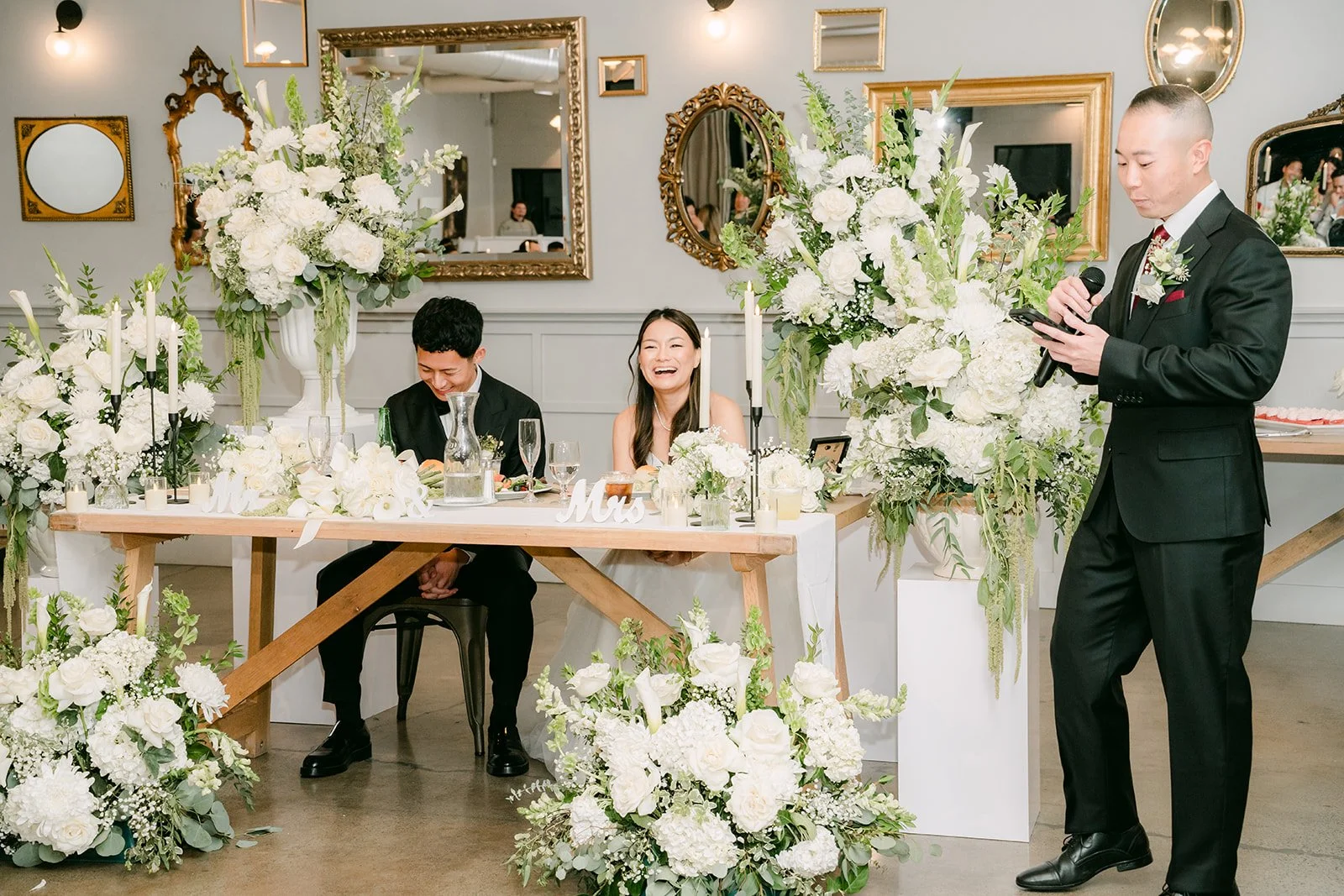Speech at the sweetheart table under the gold mirrors